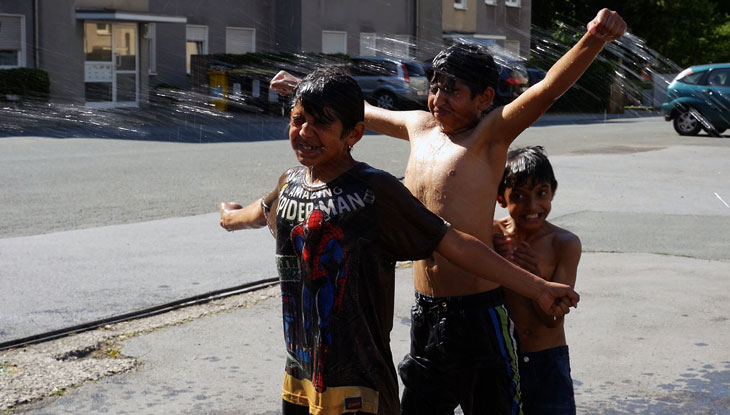 Drei Jungs machen eine Wasserschlacht auf der Straße