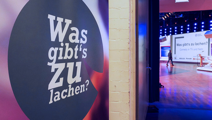 Logo der Veranstaltung: Ein lachendes, abstrahiertes Emoticon mit der Aufschrift: Was gibt's zu lachen? am Studioeingang der heute-show